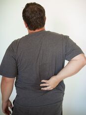 image of man holding his lower back in pain